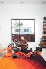 In the light-flooded living room, Hernandez does a little work on a 1976 Italian-made Harley-Davidson SXT125.