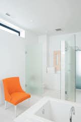 The master bathroom, with its frosted glass walls and chair (rescued from the trash pile and rehabbed), is large and elegant enough to serve as a gathering place for parties.