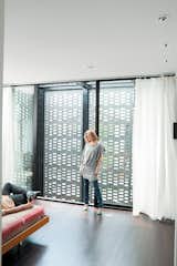 Bedroom, Bed, and Dark Hardwood Floor In the master bedroom, the couple enjoy the ample natural light that filters through the brick screen.  Photo 6 of 10 in The Brick Weave House in Chicago