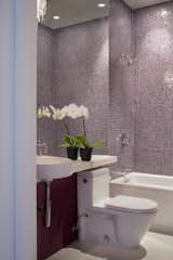 The main-level bathroom is finished quite similarly to that of the master suite: an Arcitec sink and Stark 2 toilet by Duravit, a crystal sconce by Eurofase, and tiles by Bisazza.Photo by Sharon Risedorph