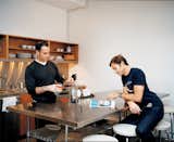 Weinstein and partner Eric Hensley at the stainless steel work table in the kitchen. The table, pantry doors, and sink backsplash are all made from simple wood forms the architects had wrapped by a metal fabricator—something anyone can do.  Photo 2 of 6 in A Midcentury Manhattan Loft
