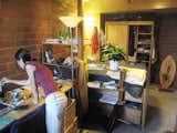 The wooden pole is the center spoke for the surrounding shelves, and divides 'sleeping space' from 'work space.'