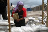 Olga Jonkers compacting the sandbags for her house's wall.  Photo 4 of 9 in Luyanda Mpahlwa