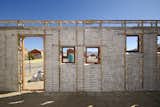 After the walls of the first-floor frames were filled tightly with sandbags, the workers plastered wire mesh onto the exterior. Image courtesy Interactive Africa/ Design Indaba  Photo 5 of 9 in Luyanda Mpahlwa