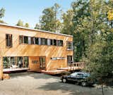 Wieler and Tung enjoy two of the home’s several decks.The home is clad in red cedar siding and features a multitude of view-enhancing windows by Loewen. The decking is composite wood by Trex.  Photo 1 of 12 in Prefab, Proven