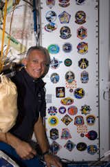 NASA astronaut John "Danny" Olivas, STS-128 mission specialist, poses for a photo with the growing collection, in the Unity node, of insignias representing crews who have worked on the ISS.Photo taken September 7, 2009. 

Courtesy of NASA