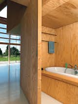 Bath and Drop In Cubic bookshelves do double duty as a dividing wall and as a sliding door opening up to a hidden bath.  Bath Drop In Photos from Modern Wooden A-Frame Retreat in France