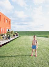 Outdoor and Grass Five-year-old Thomas Dochter plays outside the houses.  Search “take five” from Modern Communal Living in the Netherlands