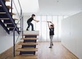 Staircase, Metal Railing, and Wood Tread The open-tread stair leading from the garage to the second-floor living room sets the stage for a Star Wars–style duel.  Search “from-the-floor-brinca-dada.html” from Small Box Home With Black Metal Facade in Japan