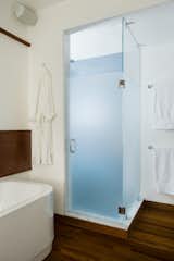 The shower is one corner of the renovated bathroom and adds a slash of color—a blue to match the color of the Aegean Sea as the homeowner remembered it after a trip to the Mediterranean.Butz and Klug chose towels bars and accessories from 

Dornbracht to finish the room’s look.Photo by 

Eric Roth  Photo 1 of 68 in Bathroom by Mike Muldoon from Loo & Improved