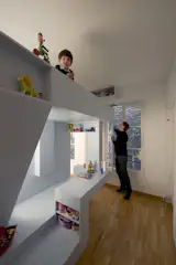 It's hard to be small and see the world from the eye level of adults' knees. In the children's bedroom, Eva's viewing perspective is reversed, and she observes her brother and parents from on high as she perches in her bed.