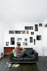 Mathieu Vinciguerra reads in front of his apartment’s signature storyboard shelves.
