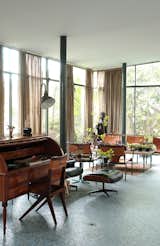 The living area of Lina Bo Bardi's Glass House, a modern villa above São Paulo, held many of the architect's furniture designs, including the desk chair and dining chairs. Both shared the similar elements of corsetlike back stitching, a motif still replicated today.