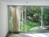 A previous owner, rather than replacing the imploded air vents in the cement slab, had installed radiators, chewing up the diminutive white ceramic tiles and ruining the visual impact of the glass.  Photo 13 of 17 in Mod Men