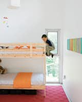 In the kids’ room, Jack climbs the bunk bed he shares with his little brother, James. The paintings on the wall were done by their mom.