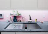Painting this diamond-plate steel backsplash a charming pink color makes the material feel less cold and industrial.