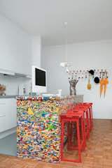 Kitchen, White Cabinet, Medium Hardwood Floor, and Pendant Lighting The idea for Simon Pillard and Philippe Rossetti’s Lego kitchen island in Paris sprouted when Pillard put 500 blocks and a day’s worth of work into building a Lego-legged chair. They covered their kitchen island—a simple wooden block—with 20,000 Lego pieces.  Search “Worth the Wait otg” from Lego Island