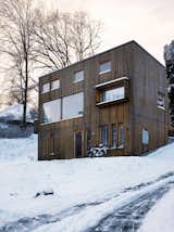 Exterior, Cabin Building Type, Wood Siding Material, and Shed RoofLine The facade is punctured by a variety of differently sized windows: Those flush to the wall indicate the house’s public rooms, while the those for the private spaces are set back.  Photos from Knotty by Nature