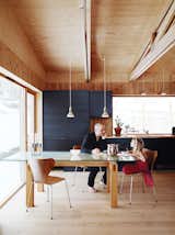Dining Room, Pendant Lighting, Light Hardwood Floor, Table, and Chair Bornstein and his daughter Velma sit at a table the architect designed himself; the dining chairs were designed by Arne Jacobsen for Fritz Hansen.  Search “design-build” from Knotty by Nature