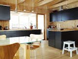 Kitchen, Wood Cabinet, Pendant Lighting, Wood Backsplashe, Drop In Sink, Wood Counter, and Light Hardwood Floor The kitchen is from Ikea and the dining chairs by Arne Jacobsen, but the table is pure Bornstein.  Photo 1 of 16 in Mid-Century Renos by David M. Dreger from Knotty by Nature