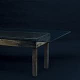 The Abuletada is a dining table with a glass top attached to a humble wooden base.
