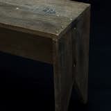 In a truly alchemical mixture of high and low, this bench-table is fashioned with golden nails.