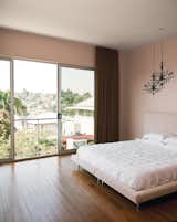 The Owenses’ minimalist master bedroom features Blik wall decals of chandeliers.