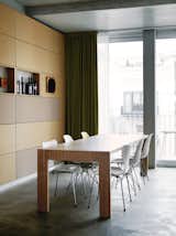Dining Room, Concrete Floor, Table, and Chair Next to the kitchen, Eames and Jacobsen chairs welcome dinner guests to the dining-room table. The back wall is covered in particleboard panels.  Photo 1 of 16 in A Rational Approach