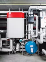 Here, in the basement, a borehole heat exchanger uses the warmth from the earth, brought to the surface by four steel pipes that reach 105 feet down, for heating. Solar panels heat the building’s water, and a clever ventilation system ensures that the glass house doesn’t get too warm in the summer.