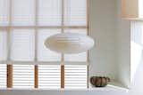 Inexpensive muslin makes a lightweight and luminous covering for windows and the pivoting glass door in the kitchen. While the roll-up shades fabricated by Van Nuys Awning Co. resemble a ship’s sails, the hardware for the cords calls to mind boat cleats. Both are fitting nautical references as the house is located only blocks away from the ocean.  Photo 11 of 13 in Coast Docs