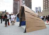 Self-replicating nanobots were the foe of Turner Construction, who designed a central tension ellipsoid ring structure as the basic connection between roof and vertical support, complete with cardboard scales and community signage flags.  Photo 10 of 13 in Allez Design! NYC's Iron Designer by Tiffany Chu