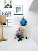 Johnny Lökaas and Conny Ahlgren pose in their living room with some of their art collection, which includes a Julian Opie portrait and works by Keith Haring and others. Space to show the art and good light for viewing it were the priorities.