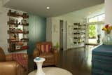 A view from the living area toward the addition, and the transition of old to new. The existing study, where Lyall often writes, is reached through the new opaque teal doors that slide into the wall (one slides behind the open bookshelf at left). Beyond the sliding white door is the master bedroom and bathroom.  Photo 4 of 9 in The Barn and the Lantern