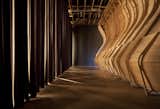 To enter the installation, you walk through a curtain made of curling lengths of polarfleece, and glimpse the exterior wooden skeleton of the structure.