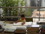 Orlovski and Aratoâs son at work in dadâs studio, to which the architect added a large, roll-up door that when raised, opens the space completely to the backyard patio and main house. The houseâs dining room is at right; behind the plantings is the master bedroom.