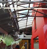 One major move was to break up the floor slabs of all the encircling factory warehouses, in order to create huge vertical volumes of space for contemporary art exhibitions. The glass roof covering the central house was preserved, as were the original proportions and structural system of metal rivets.  Photo 6 of 6 in Radical Red Houses by Erika Heet from The Red House, Paris