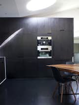 Kitchen, Wall Oven, and Dark Hardwood Floor A wall of built-ins in the kitchen houses a raft of Miele appliances including a refrigerator, microwave, and espresso machine.  Search “kickstarter nick black new black color” from Designed In-House