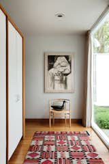 The main entry, located off the front courtyard is more practical than grand. The door opens onto a PK15 chair by Poul Kjaerholm and built-in coat cabinets that direct movement to either side of the hall and into the living area.
