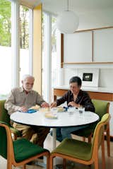 Isaacson and his best friend, Mary T. Hatch, snack at a dining table by Charles and Ray Eames for Herman Miller in the eat-in kitchen.