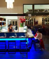 The ceviche bar wraps around into the dining hall, where the tables are elevated off the floor to lift them off the concrete but to also offer a level surface as the existing floor slopes nine inches from water end to land end. Here, we were treated to Pico sours and delicious corn empanadas. Photo by Eric Laignel.