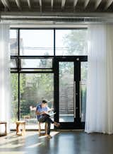 In the house’s front room Monkman relaxes on a stool from local retailer Andrew Richard Designs. A new window system draws in sunlight and views of the front courtyard designed by local landscape architect Terry McGlade, the building’s former owner.
