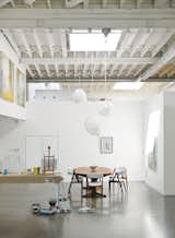 Inside, white paint lightens up the middle of the building. A vintage Danish dining set and Cloud pendants by Frank Gehry for Vitra define the dining area.