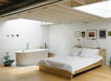 In Toronto, a painter accustomed to crashing in his studio created an airy artistic haven with both working and living quarters for a more balanced and polished picture.&nbsp;The bedroom mixes a bed and lamps from IKEA with a deep, luxurious bathtub (an inexpensive model from Neptune). The artworks include original prints by New York artist Franco Mondini-Ruiz.