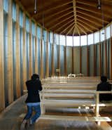 Its unconventional fish-like shape and signature wooden ceiling backbone with fins create a symmetrical, anchoring feeling while sitting in the pews.
