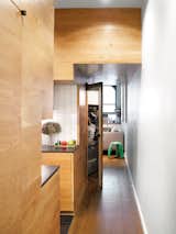 Kitchen, Wood Cabinet, Ceramic Tile Backsplashe, and Medium Hardwood Floor White oak paneling imbues uniformity and warmth into the hallway, kitchen, and living spaces.  Photo 4 of 12 in The Manhattan Transformation