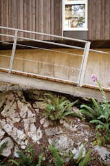 Outdoor, Flowers, Walkways, Shrubs, and Boulders Farther down on the site is a dock whose ramp is lowered by hand via weight-laden pulleys. The residence is accessible by private boat or water taxi only.  Photos from When Living on the Edge is Super Comfortable