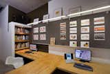 Colkitt built the plywood desks and implemented bookshelf to temper the awkwardness of the wall jutting out behind it. More Homasote work boards are illuminated by fluorescent lighting. Photo by Cheryl Ramsay  Photo 10 of 11 in San Diego Cadres by Erika Heet
