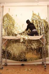 Ho at work on a golden wall installation.