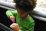 A young visitor digs in to her Triple Berry & Cream scoop in a homemade waffle cone.