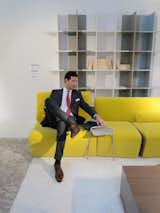 Roset demonstrating how the Philippe Nigro side table that straddles the Entailles couch is the perfect place to rest his iPad. Behind him is the Oka bookcase, which comes in three sizes that nestle together seamlessly to accommodate any book collection or wall.  Photo 8 of 23 in Maison & Objet: Part 2 by Jaime Gillin